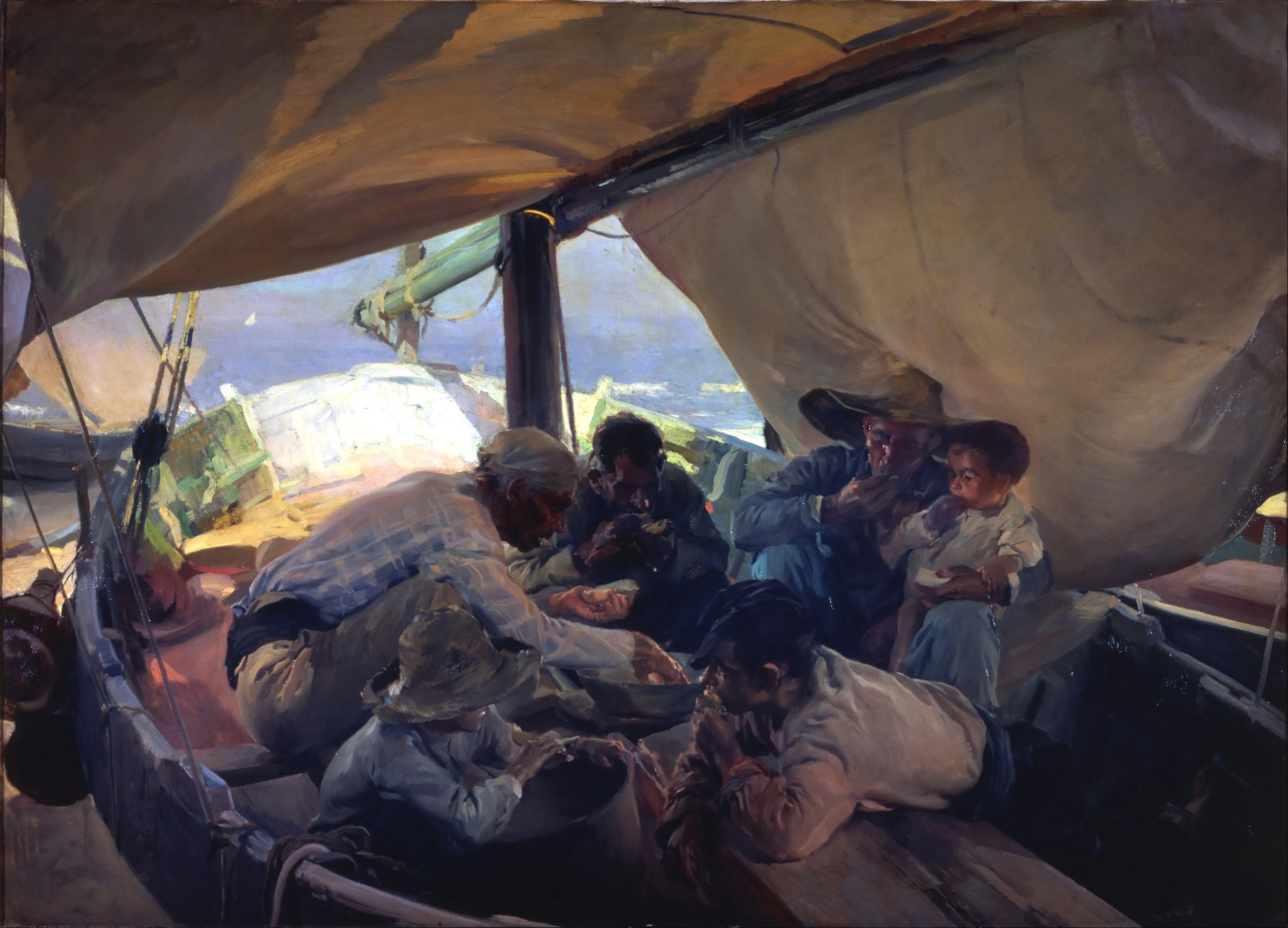 Fishermen share a midday meal in the shade of their boat's great sail, warm light glowing through the canvas over the gathered crew.