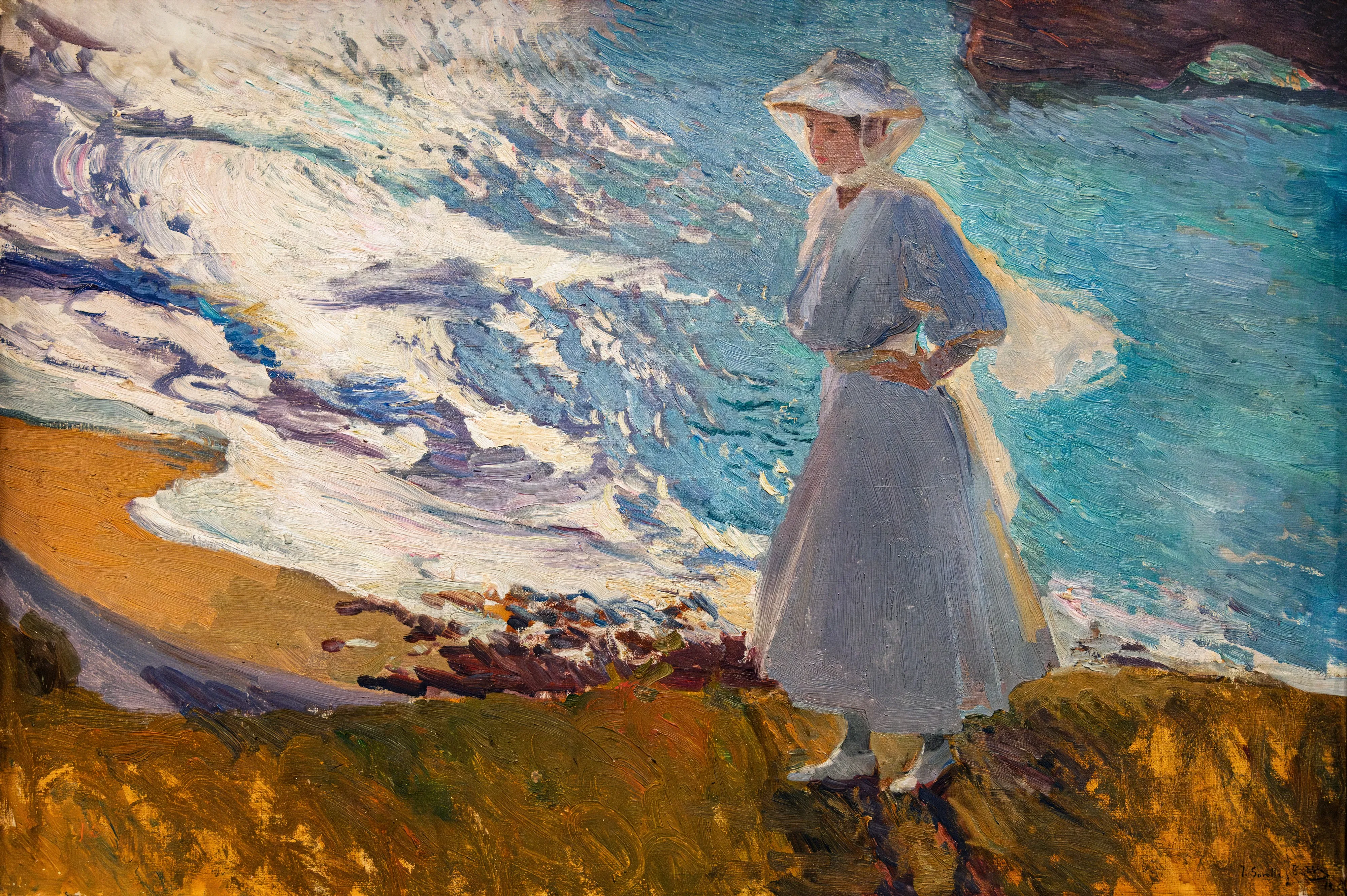 Sorolla's daughter María stands backlit at the water's edge in Biarritz, her figure haloed in light as she lifts her skirts from the waves.