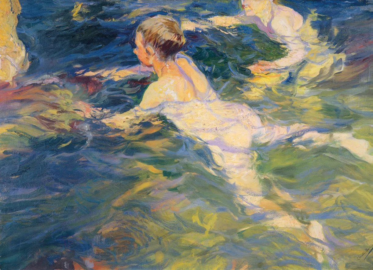 Bathers swim in the vivid, glassy blue-green water off the rocks at Jávea, sunlight fracturing across the restless, transparent surface.